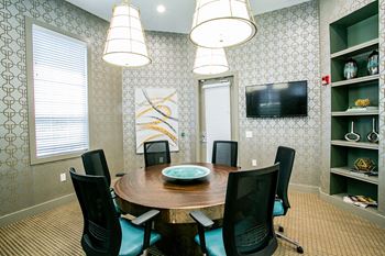 a conference room with a round table and black chairs